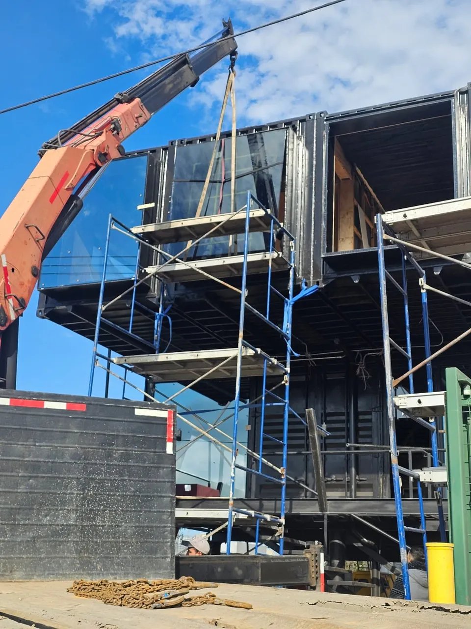 Instalación de un paño de vidrio con grúa en una fachada de empresa en Hualpén, Concepción.